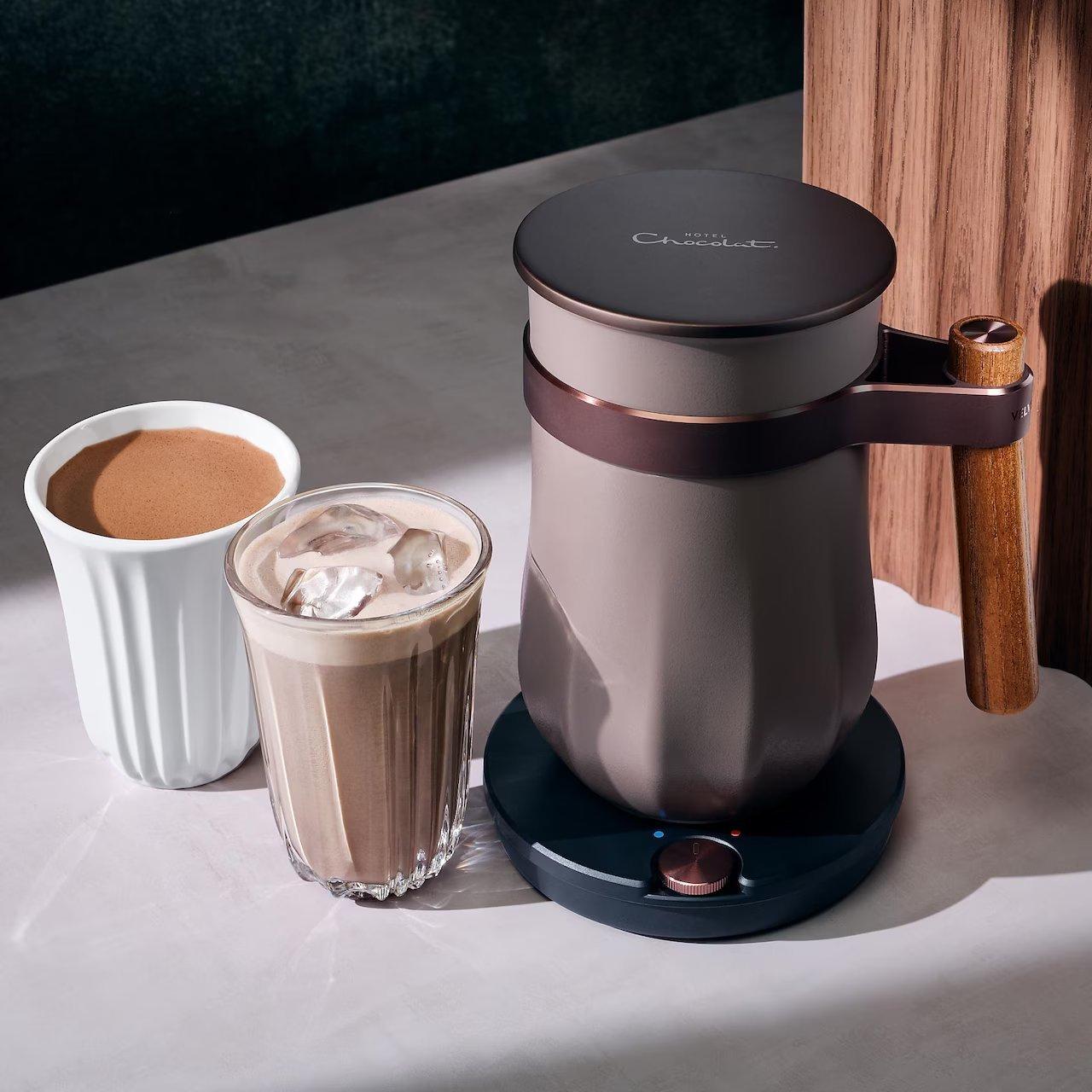 a coffee maker and a cup of coffee on a table