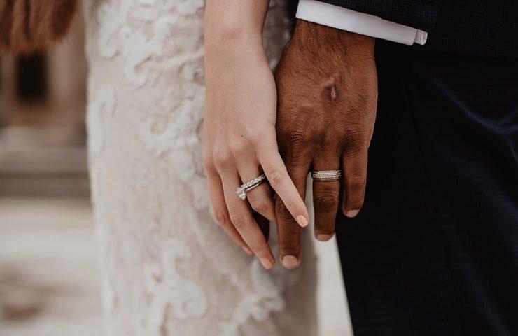 A-couple-holding-hands-wearing-wedding-rings