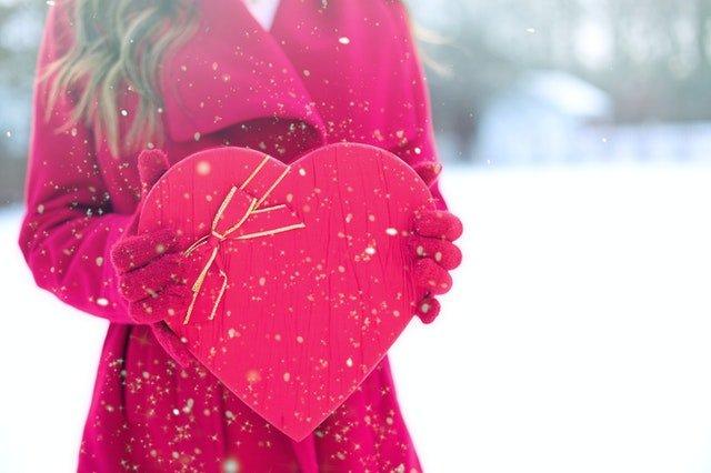 A-woman-holding-a-heart-shaped-box-of-chocolates