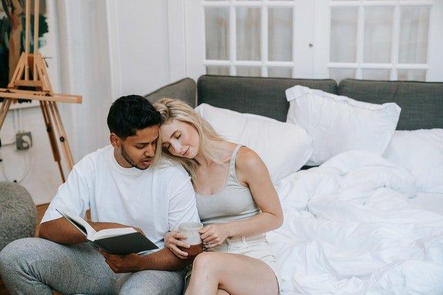 Couple-by-a-sofa-with-a-duvet-book-and-mug