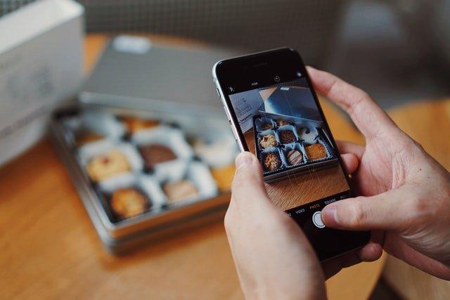Person-taking-a-photo-of-a-box-of-chocolates