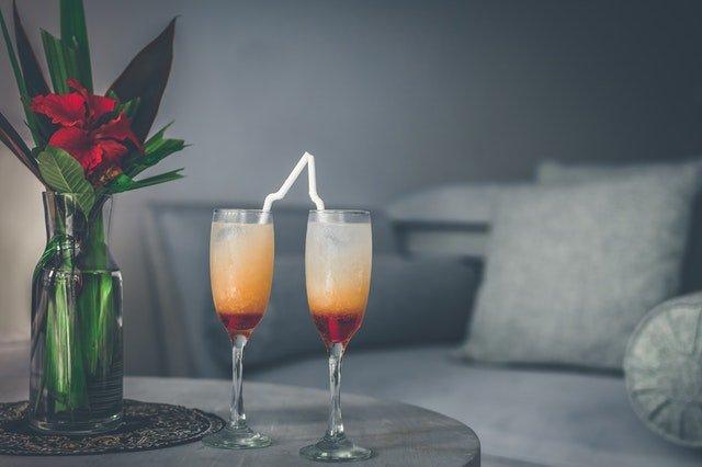 Two-glasses-of-bright-cocktails-in-living-room