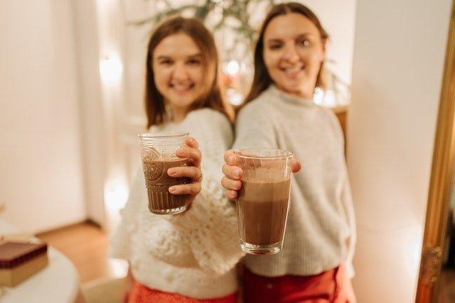 Two-young-women-holding-glasses-of-coffee
