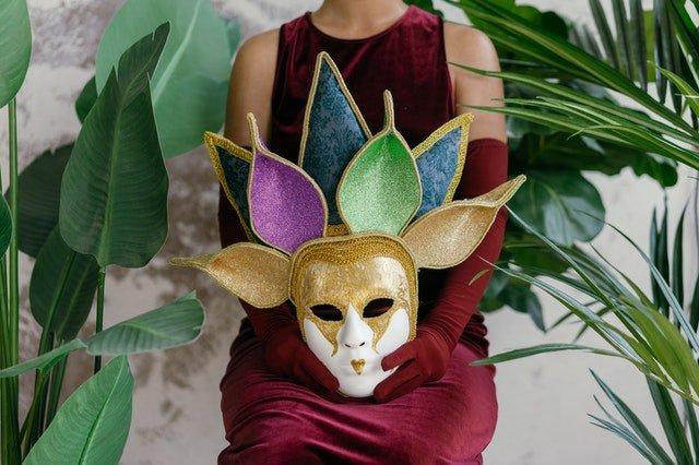 Woman-holding-a-Mardi-Gras-mask