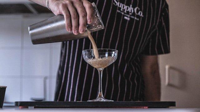 chef-pouring-cocktail-into-glass