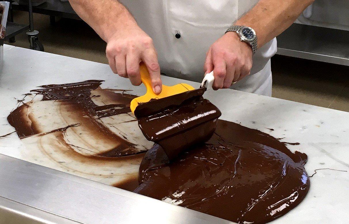 man-tempering-chocolate-on-a-marble-surface