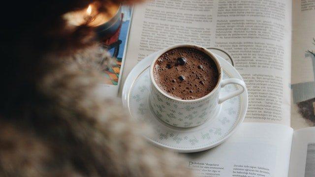 mug-of-hot-chocolate-with-candle-and-magazine